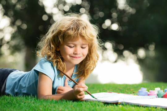 Artist kids. Portrait of smiling happy kid enjoying art and craft drawing in backyard or spring park. Children drawing draw with pencils outdoor.