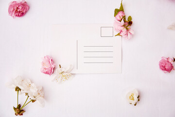 Spring festive post card mock up with pink and white flowers. Invitation, romantic, wedding, birthday, Woman's day, Mother's day card concept. Copy space. View from above.