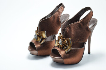 Zapatos cafés de tacón alto. Zapato de mujer para fiesta con un moño al frente, espacio para texto al lado izquierdo.