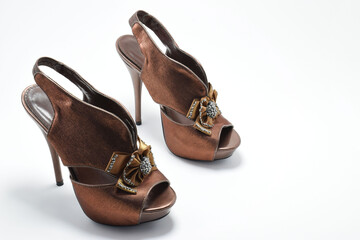 Zapatos cafés de tacón alto. Zapato de mujer para fiesta con un moño al frente, espacio para texto al lado derecho.