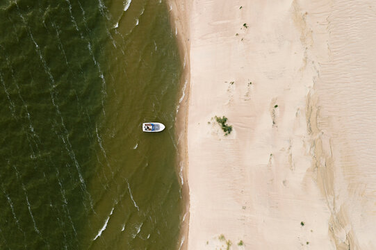Aerial view of speedboat floating near sand dune in Curonian spit, Lithuania.