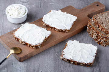 Rye bread with cream cheese on grey table
