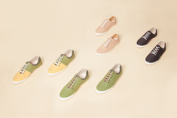 Stylish nature color sneakers isolated on beige background; space for text; top view