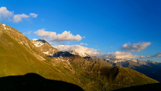 Dramatic sunset over mountains in Switzerland. Majestic mountains in warm golden light during sunset in Swiss Alps.