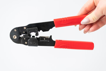 female hand holding Crimping pliers for connectors, internet cables and wires
