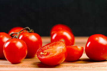 tomatoes over a wooden desk with black background