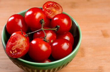 Tomatoes inside a green bowl over a wooden table