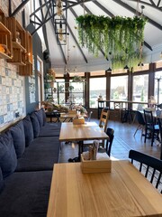 Cozy wooden interior in cafe, copy space. Comfortable modern dining place, contemporary design background