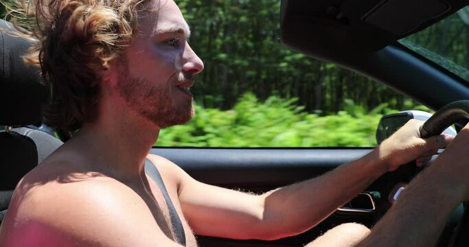 Car. Man driving Car. Happy carefree millennial man driving car on road trip in convertible car smiling with hair in the wind in summer vacation. 59.94 FPS slow motion