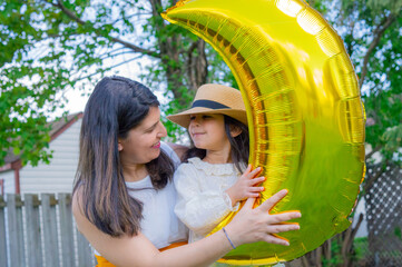 A portrait of young mother with a small daughter in summer