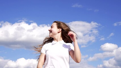 happy child enjoy the sun and wind with long hair on sky background, enjoyment