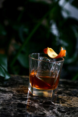 Old fashioned whiskey cocktail in glass with clear ice and orange twist 