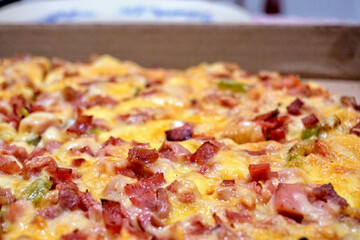 Cooked ham, sausage and cheese pizza on a cardboard box
