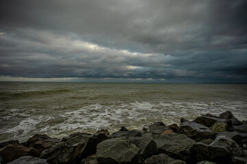 Fototapeta na wymiar dramatic sky over the black sea with waves, clouds and stones