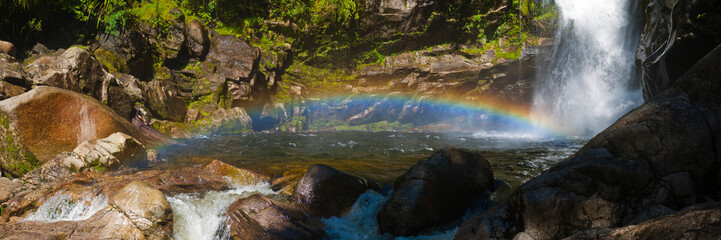 Naklejka na ściany i meble Panoramic Photo of Rainbow at Wainui Falls, a Waterfall in Golden Bay Region, South Island, New Zealand
