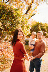 a family with a small child on an autumn walk around the city. 