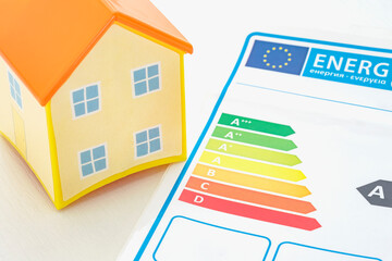 TOY HOUSE AND SCALE OF THE EUROPEAN UNION HOUSING ENERGY EFFICIENCY CERTIFICATION.