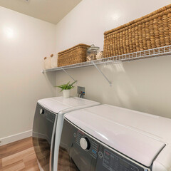 Square Laundry room with two laundry appliances and woven boxes on a metal shelf