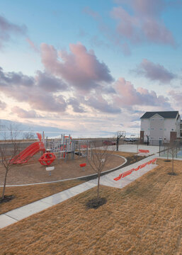 Vertical Puffy Clouds At Sunset Basketball Court, Playground And Pickleball Court In A Residenti