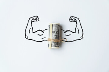 The concept of a strong world currency. Muscle hands with a bunch of us dollars money.