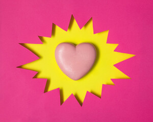 Creative pop art Valentine's day idea. Light pink heart in yellow comic speech bubble. Modern love concept. Minimal romantic flat lay composition.
