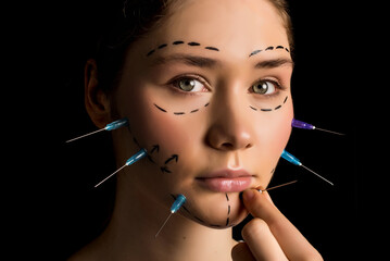 Plastic surgery concept. Beautiful young blonde woman fashion portrait with lines and syringes on...