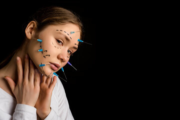 Plastic surgery concept. Beautiful young blonde woman fashion portrait with lines and syringes on...