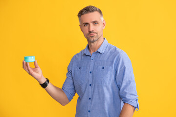 mature man with cream on yellow background, skincare