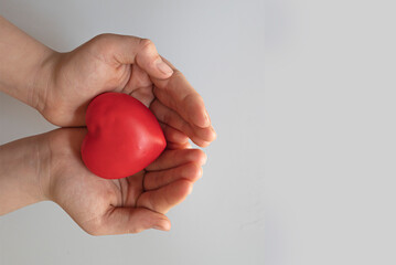 woman holding red heart on white background.heart health,donation,family insurance,life insurance concept.world heart health day.free space for text.top view.