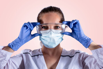 Mujer bioquímica con los elementos de protección personal de laboratorio mirando y sonriendo a...