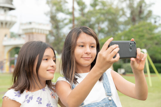 Girls sisters taking selfie photo in park