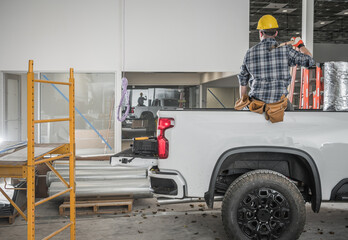 Construction Contractor Worker Taking Short Brake Seating on His Pickup Truck Cargo Bed