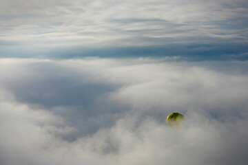 Hot air balloon that comes out from a sea of clouds