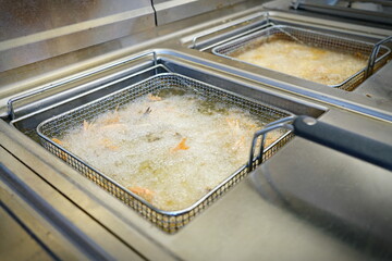 Deep fryers with boiling oil on fast food kitchen