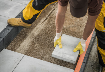 Worker Building Large Concrete Bricks Garden Path