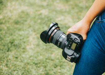 Mano sotendiendo una camara fotografica profesional