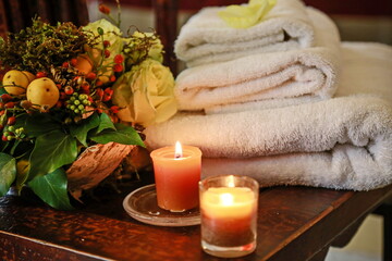 Spa still life with aromatic candles, flower and towel.