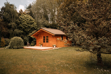 Small cottage in the countryside. Garden house made of wood. Cottage in your own garden for hobbies and free time during the pandemic. Shed in a large garden in Germany