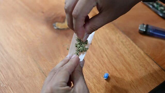 Man rolling a marijuana weed blunt