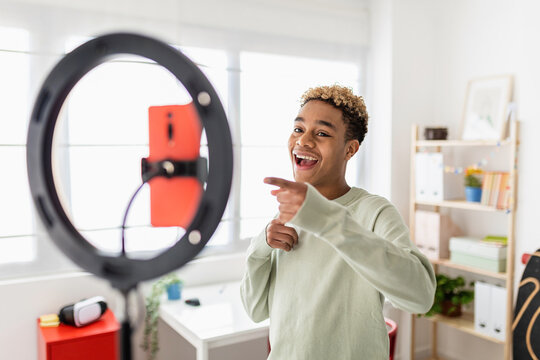 Young male creator recording online media video on his room - Millennial guy streaming online and sharing social media content by mobile phone app network - New trends for millennial people concept