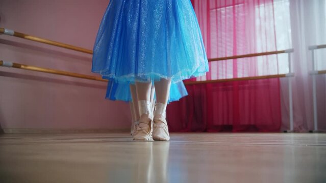 Four ballerina girls in blue dresses walk in a row and go around