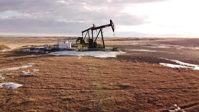 Cremona Alberta Canada, January 22 2022: Aerial flight near a working pump jacks oil field on the Canadian Prairies.