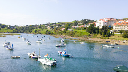 Boats on a harbor near a town with hills