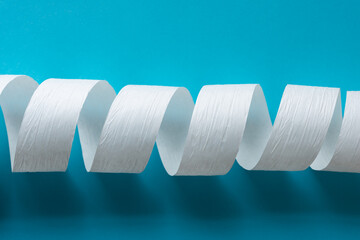 white paper ribbon coil on blue
