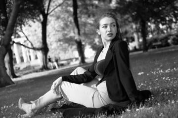 Black and white portrait of a young girl in the city park. Elegant and melancholy portrait, the...