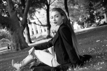 Black and white portrait of a young girl in the city park. Elegant and melancholy portrait, the...