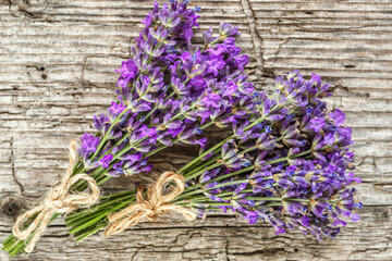 lavender's spa products with dried lavender flowers on a wooden table. Flat lay bath salt and massage oil on wooden background. Skin care, beauty treatment concept. Lavendula oleum
