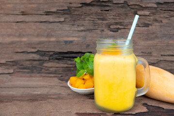 Mango juice fruit smoothies yogurt drink yellow healthy delicious taste in a glass slush for weight loss on wooden background.