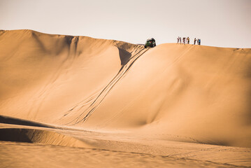 Sand boarding on dunes in the desert at Huacachina, Ica Region, Peru, South America