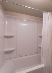 Vertical Interior of a bathroom with paneled acrylic wall on the shower tub